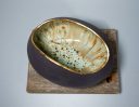 Handbuilt black clay vessel with turquoise glaze and gold lustre