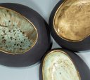 Close-up of glazed interiors in three handmade black clay vessels